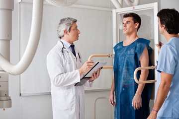 Fototapeta premium Radiologists Conducting X-ray On Male Patient