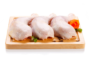 Raw chicken legs on cutting board on white background