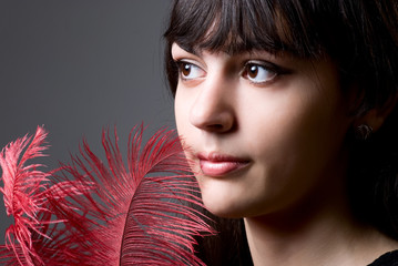 Close-up portrait of girl with red feathers