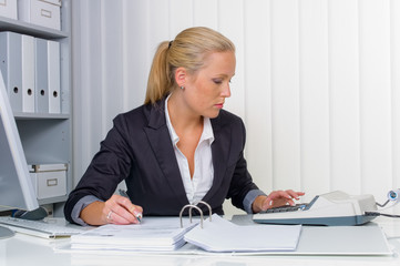 Frau im Büro mit Rechenmaschine