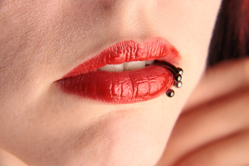 Die roten Lippen einer Frau mit Piercing