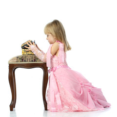 A girl in a pink dress opens the box