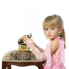 A girl in a pink dress opens the box