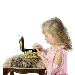 A girl in a pink dress opens the box