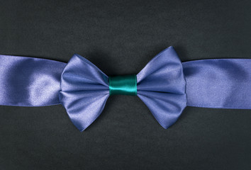 blue ribbon bow on black paper