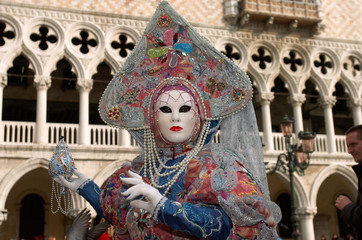 Person in Venetian costume attends Carnival of Venice.