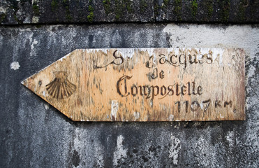 Panneau de direction ancien en bois orné d'une coquille Saint-Jacques pour la randonnée sur le chemin de Saint-Jacques de Compostelle - Dordogne, France