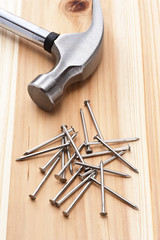木のテーブルに金属ハンマーと釘