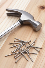 木のテーブルに金属ハンマーと釘