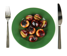 roasted chestnuts in the green plate with fork and knife