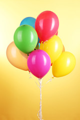 Colorful balloons on yellow background