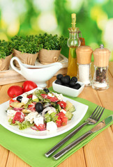 Fresh greek salad on plate on wooden table on natural
