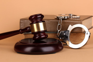 Gavel, handcuffs and.book on law on beige background