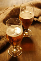 Glasses of beer on wooden table close-up
