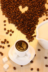 A cup of strong coffee and sweet cream on wooden table close-up