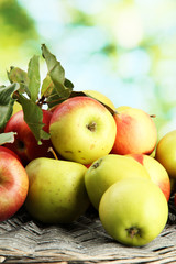 juicy apples with leaves, on green background