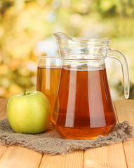 Full glass and jug of apple juice and apple