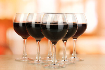 Red wine in glass on room background