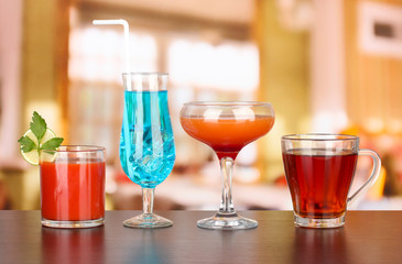 Several glasses of different drinks on bright background