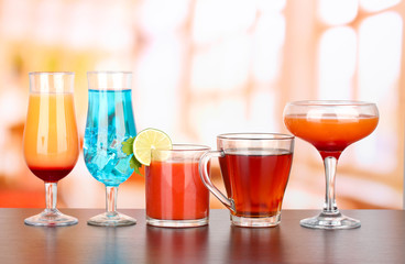 Several glasses of different drinks on bright background