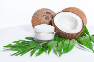 cream in a jar and coconut over white background