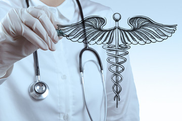 doctor draws Caduceus on white board