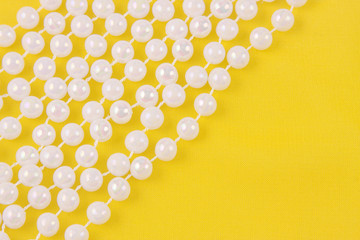 beads from white pearls on yellow fabric