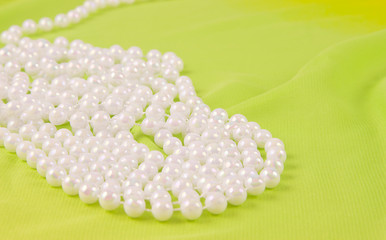 beads from white pearls on green fabric