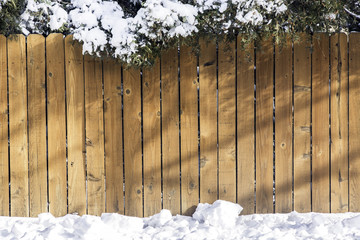 Wooden fence with snow on the top