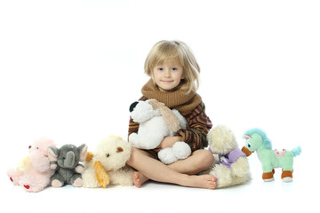 The girl in the adult sweater playing with soft toys