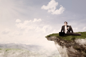 Businessman sit on top of mountain