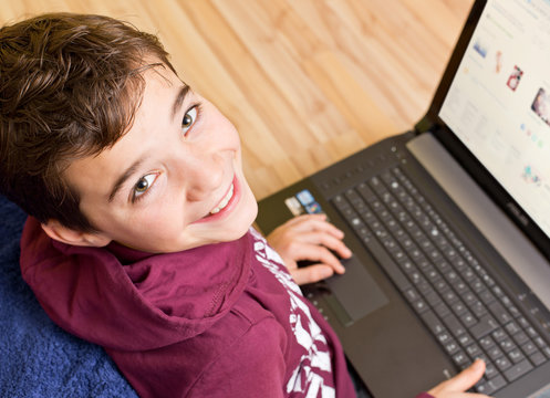 Freundlicher Junge -  Kind mit Notebook - Laptop auf dem Schoß