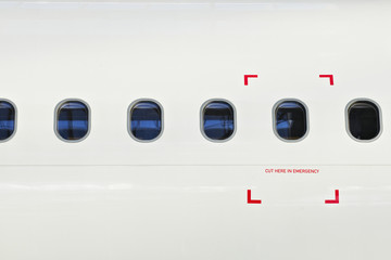 Windows of airplane with emergency sign.