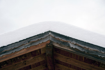 Detail of a gable rooftop covered with snow.