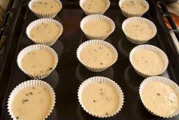Raw dough into muffins in the forms .