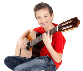 Smiling boy is playing on acoustic guitar