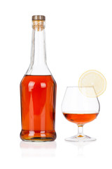 Congac bottle with glass and lime isolated on white