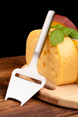 Various types of cheese and knife isolated on black