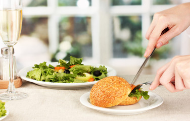 Female hand with  dinner on bright background