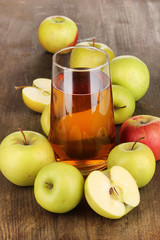 Useful apple juice with apples around on wooden table