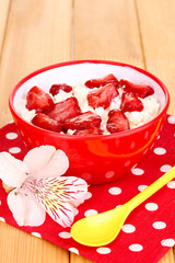 Cottage cheese in red bowl with sliced strawberries