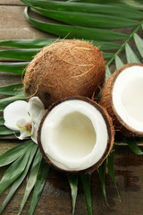 Coconuts with leaves and flower, on grey wooden background
