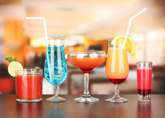 Several glasses of different drinks on bright background