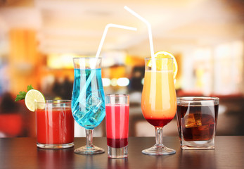 Several glasses of different drinks on bright background