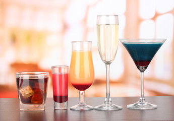 Several glasses of different drinks on bright background