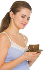 Thoughtful young woman in pajamas after sleep with cup of coffee