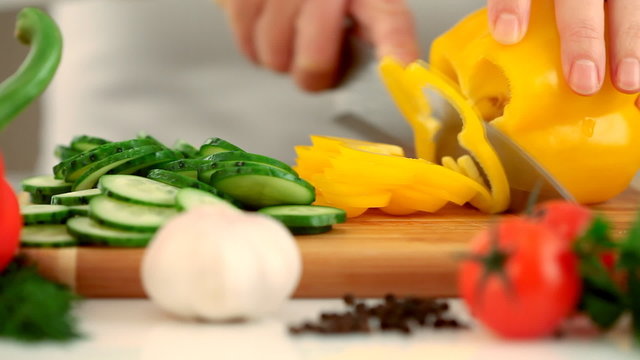 Female hands chopping yellow paprika(pepper)