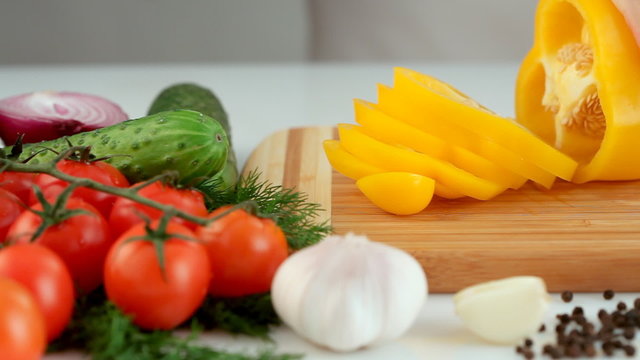 Female hands chopping yellow paprika(pepper)