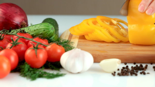 Female hands chopping yellow paprika(pepper)