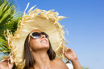 Woman with hat by the sea